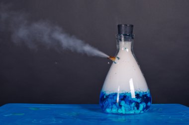 Blue bottle with dry ice soars. clipart
