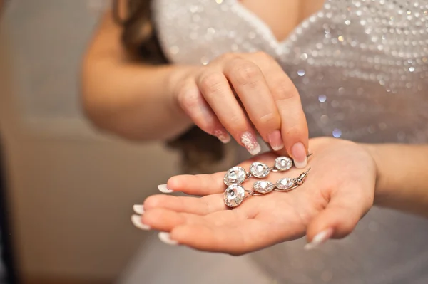 Earrings from pearls in hands. — Stock Photo, Image