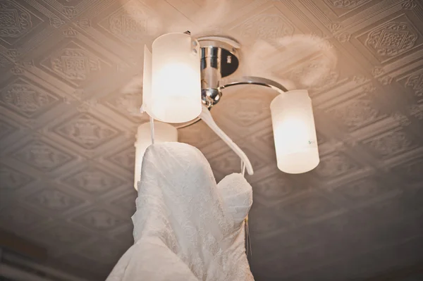 Wedding dress on a chandelier. — Stock Photo, Image