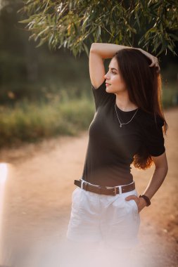 Doğada batan güneşin ışınlarında neşeli bir güzellik yürüyor..