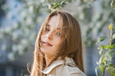 Kiraz çiçeğinin arka planında kızıl saçlı bir güzelliğin portresi..