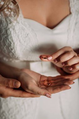 Alyansları olan yeni evli çiftin ellerini nazikçe kucaklayın..