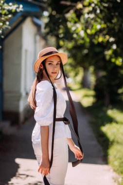 Bahar güneşinin altında bir kız yürüyor şehrin etrafında.