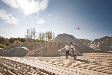 Bir çocuk gökkuşağı uçurtması fırlatır.