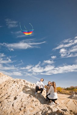Bir çocuk gökkuşağı uçurtması fırlatır.