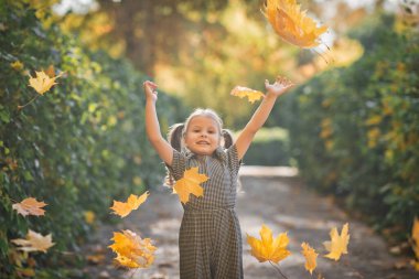 Bir çocuk sonbahar yapraklarını kusar..