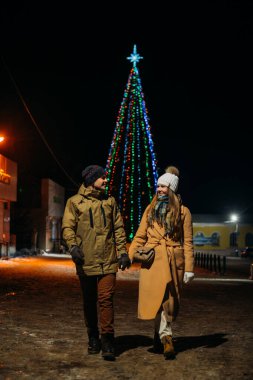 Şehrin yeni yıl ışıklarının arka planında birbirine aşık bir çiftin büyük bir portresi..