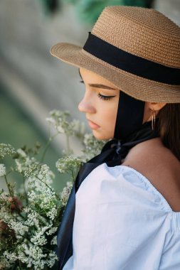 Siyah kurdeleli ve şapkalı büyük bir kadın portresi..