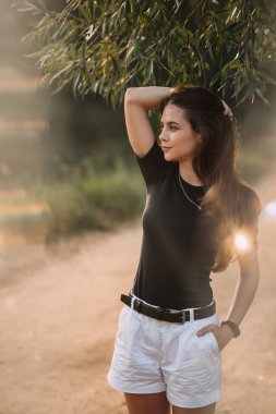 Doğada batan güneşin ışınlarında neşeli bir güzellik yürüyor..