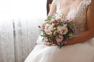 Gelin bir buketin içinde bir sandalyede.