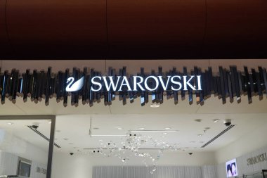 Bir butik Swarovski mücevheri. Swarovski, Avusturyalı kurşun cam üreticisi. Swarovski kuğu sembolü ve bir mağaza cephesinde logo. : Dubai BAE - Şubat 2022