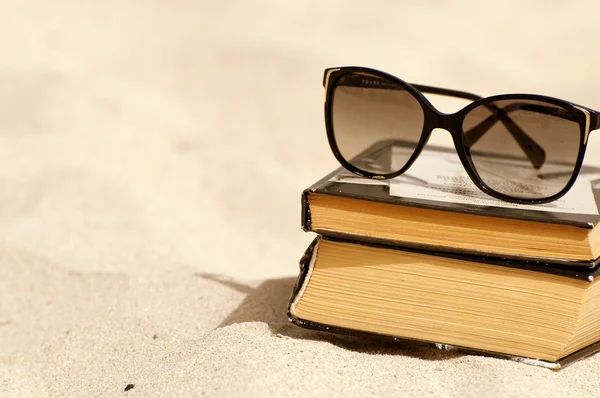 Books and sunglasses on a beach — Stock Photo, Image