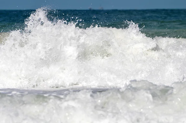 Schiuma di mare bianca su una spiaggia — Foto Stock