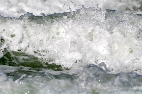 Espuma de mar branca em uma praia — Fotografia de Stock