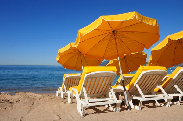 Bright yellow umbrellas on a sand beach — Stock Photo, Image