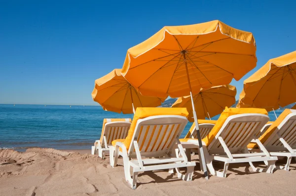 Helder gele paraplu's op een zand strand in cannes, Frankrijk — Stockfoto