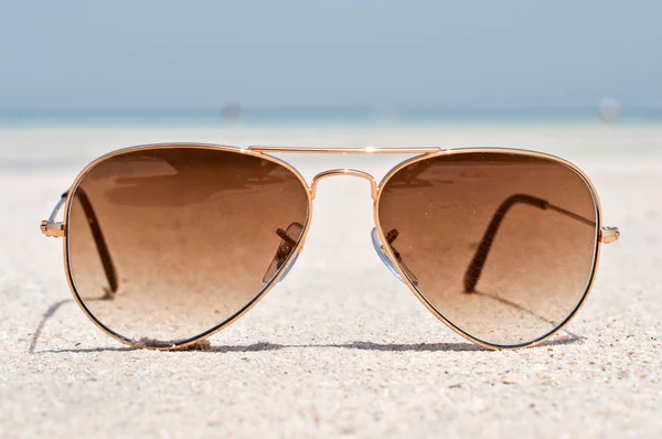 Lunettes de soleil sur une plage de sable — Photo