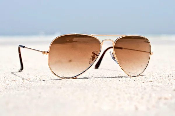 Gafas de sol en una playa de arena —  Fotos de Stock