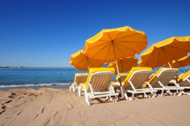 bir kum plajı üzerinde parlak sarı şemsiye