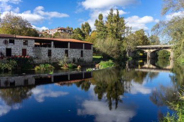 ŞİRİZ, İspanya - 22 Ekim 2021: Coiro müzesi İspanya 'nın Orense kentindeki Allariz kasabasındaki suya yansıdı.