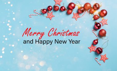 Noel süslemeleri, kırmızı Yeni Yıl topları. Mavi arka planda, kar taneleri, ışıltılar, konfetiler olan bir çerçeve.