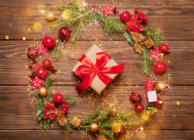 Noel şenlikli çelenk dalları kırmızı oyuncaklar kırmızı kurdele yılanı hediye eder. Noel için yeni yıl kartı.