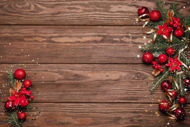 Şenlikli Noel arkaplanı kırmızı toplar yeşil dallar ladin yılanı ahşap arkaplan.