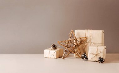 Kağıt işçiliği origamisinden yapılmış Noel ağacı bej renkli arka planda sade bir tahta yıldızın içinde paketlenmiş..