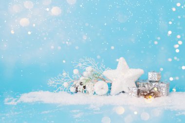 Noel oyuncakları, pastel mavisi arka planda yıldız paketleri, kar parıltıları. Yazmak için yeri olan Noel ya da Yeni Yıl kartı.