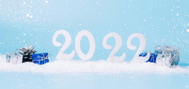 Yeni yıl 2022, tebrik kartı düzenleme pankartı. Mavi arka planda 2022 yılbaşı oyuncağının şenlikli kompozisyonu