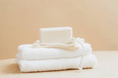 Doğal hammaddeden yapılmış sabun kalıpları beyaz yumuşak havlu bej arka plan. Organik kozmetik ürünleri. Spa sağlık konsepti