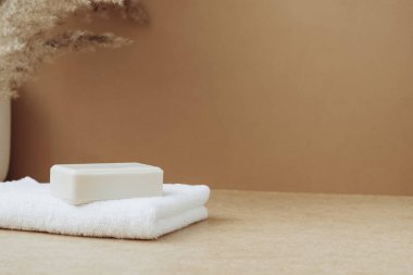 Doğal hammaddeden yapılmış sabun kalıpları beyaz yumuşak havlu bej arka plan. Organik kozmetik ürünleri. Spa sağlık konsepti