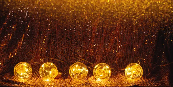 Guirnalda festiva de Navidad de bombillas doradas fondo brillante con lentejuelas y destellos. Concepto fiesta celebración —  Fotos de Stock