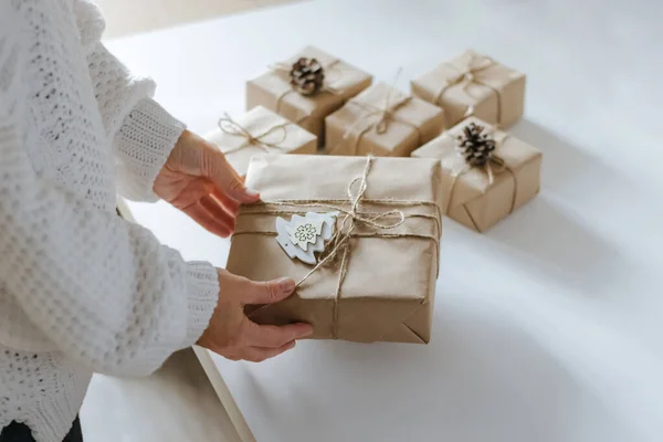 女性の手はクリスマスの包装のギフトのために準備している。冬の休暇の準備創造的な贈り物の装飾を作る — ストック写真