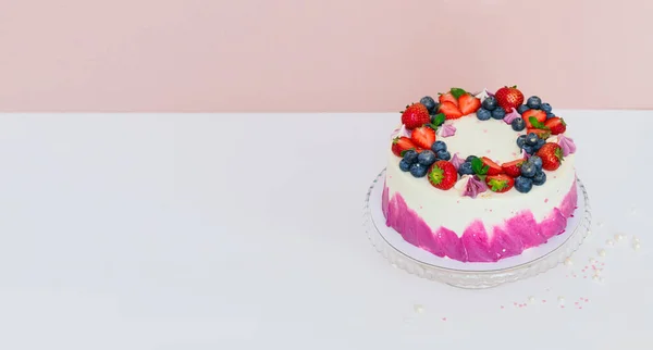 Ніжний торт, прикрашений свіжими ягодами, полуницею та чорницею на світлому звичайному тлі — стокове фото