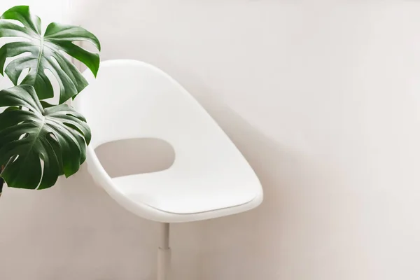 밝은 벽에 기대어 하얀 집 안락 의자, 현대 아파트의 내부. 휴식을 취하거나 온라인에서 일할 수있는 아늑 한 모서리 — 스톡 사진