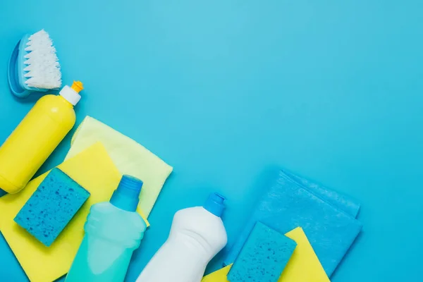 Kit de limpieza detergentes servilletas esponjas guantes, fondo azul. El concepto de servicios de limpieza del hogar o empresa de limpieza — Foto de Stock