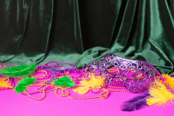 Festive carnival mask for Mardi Gras festival, green velvet curtain purple background. Masquerade — Stock Photo, Image