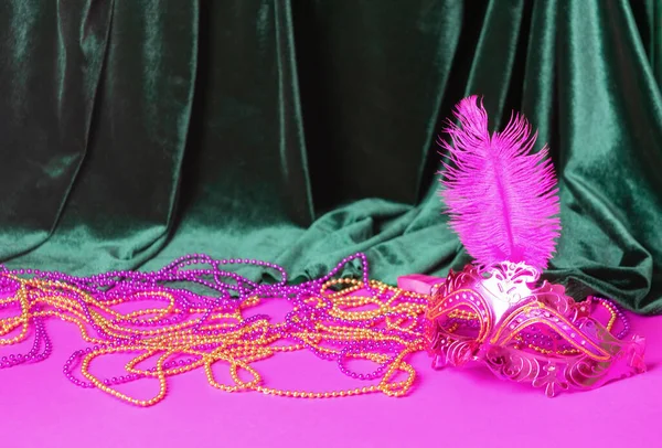 Festive carnival mask for Mardi Gras festival, green velvet curtain purple background — Stock Photo, Image