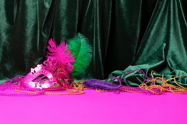 Festive carnival mask for Mardi Gras festival, green velvet curtain purple background — Stock Photo, Image