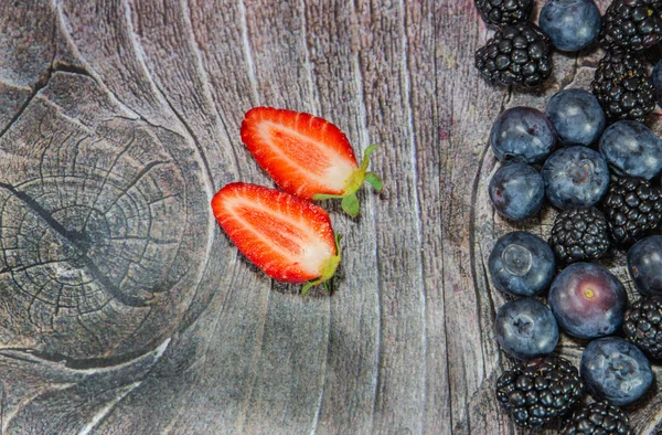 Zwei geschnittene Erdbeeren mit Brombeeren — Stockfoto