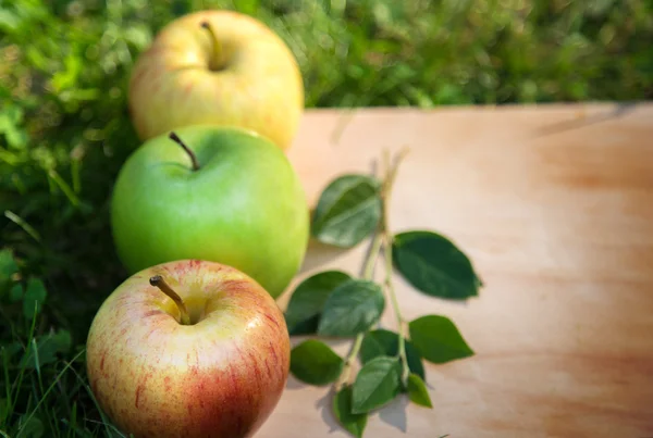 Tres manzanas sobre madera — Foto de Stock