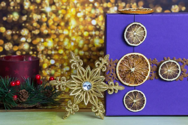 Gift box with Christmas snowflake and candle — Stock Photo, Image