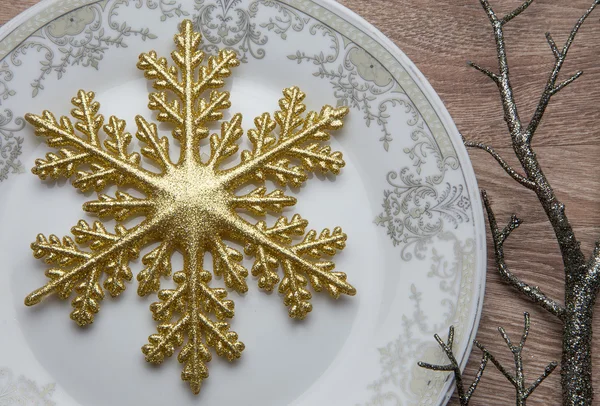 Fiocco di neve d'oro sul piatto durante la vigilia di Capodanno — Foto Stock