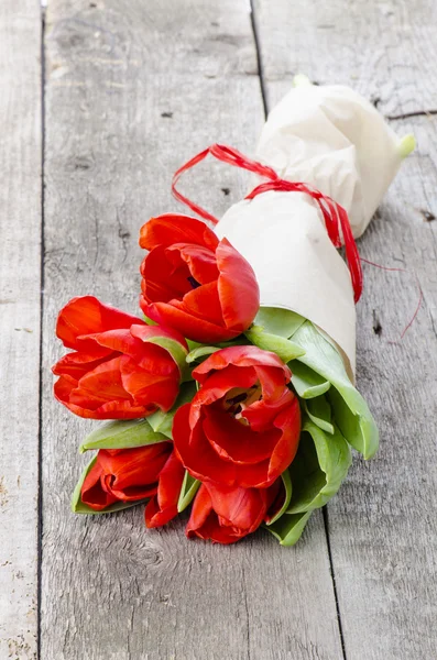 Bouquet di tulipani rossi avvolti in carta Fotografia Stock