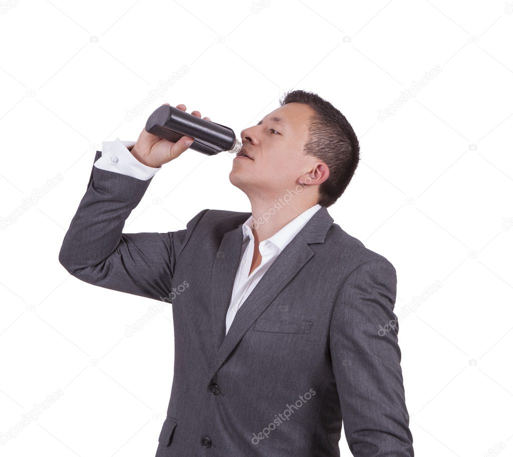 Businessman drinking water while standing against white
