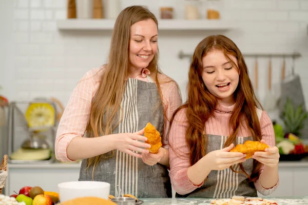 Kafkasyalı anne kızıyla birlikte mutfakta kruvasan pişirmeyi seviyor ve aile aktivitelerinden memnun görünüyorlar..