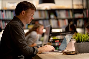 Kafkasyalı işletme müdürü, projesini bitirmek için gece ekibinde laptopuyla ciddi bir şekilde çalışır ve konsantre olur..