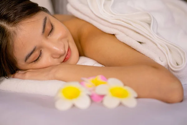 아름다운 아시아 여성을 침대에 눕히고 여성의 건강을 마사지 스파를 느낌으로 — 스톡 사진