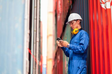 Mavi yakalı ve güvenlik üniformalı Kafkas kargo konteynırı. Ürünü kontrol etmek için barkod tarayıcısı kullanın ve iş yerindeki tankların arasında kalın..